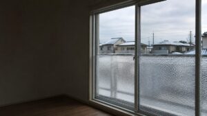 掃き出し窓のガラス下半分に気泡入りの断熱シートを貼った日本の住宅の室内