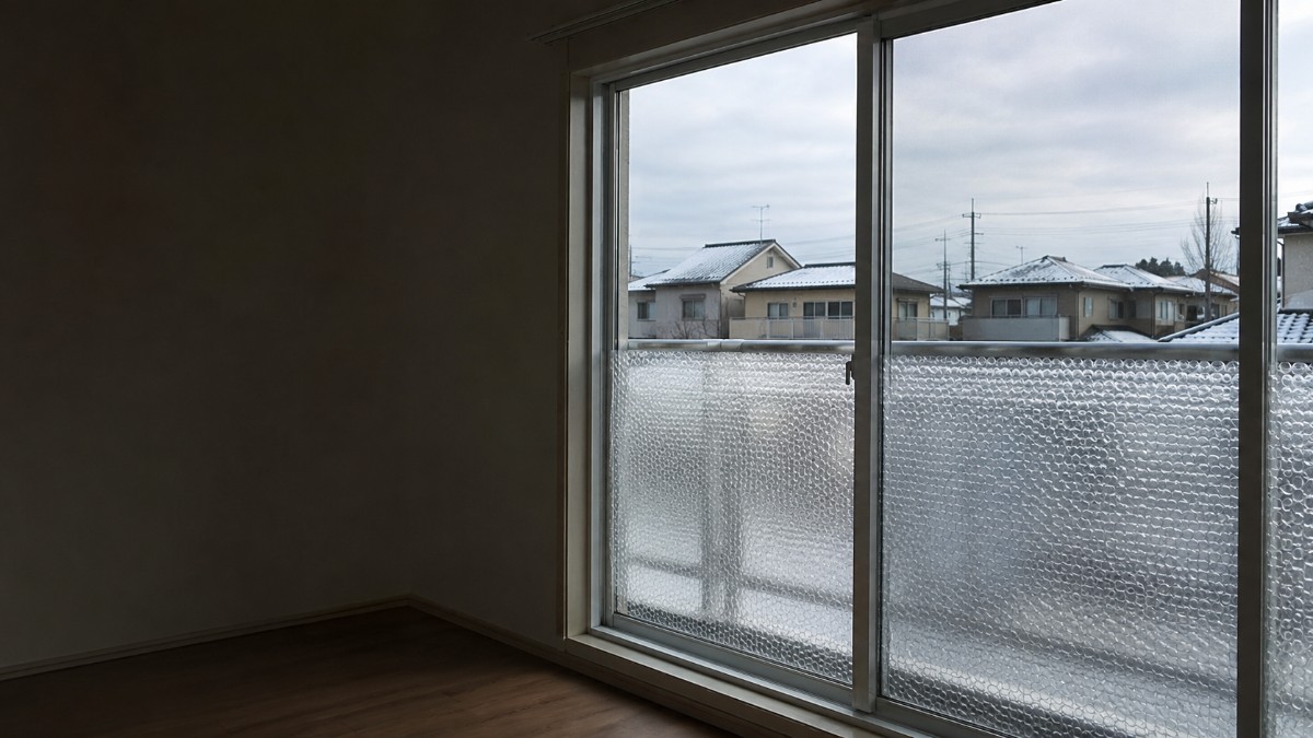 掃き出し窓のガラス下半分に気泡入りの断熱シートを貼った日本の住宅の室内