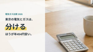 机の上に置かれた電気の検針票と電卓。東京の電気とガスは分けるほうが年454円安いという記事のアイキャッチ